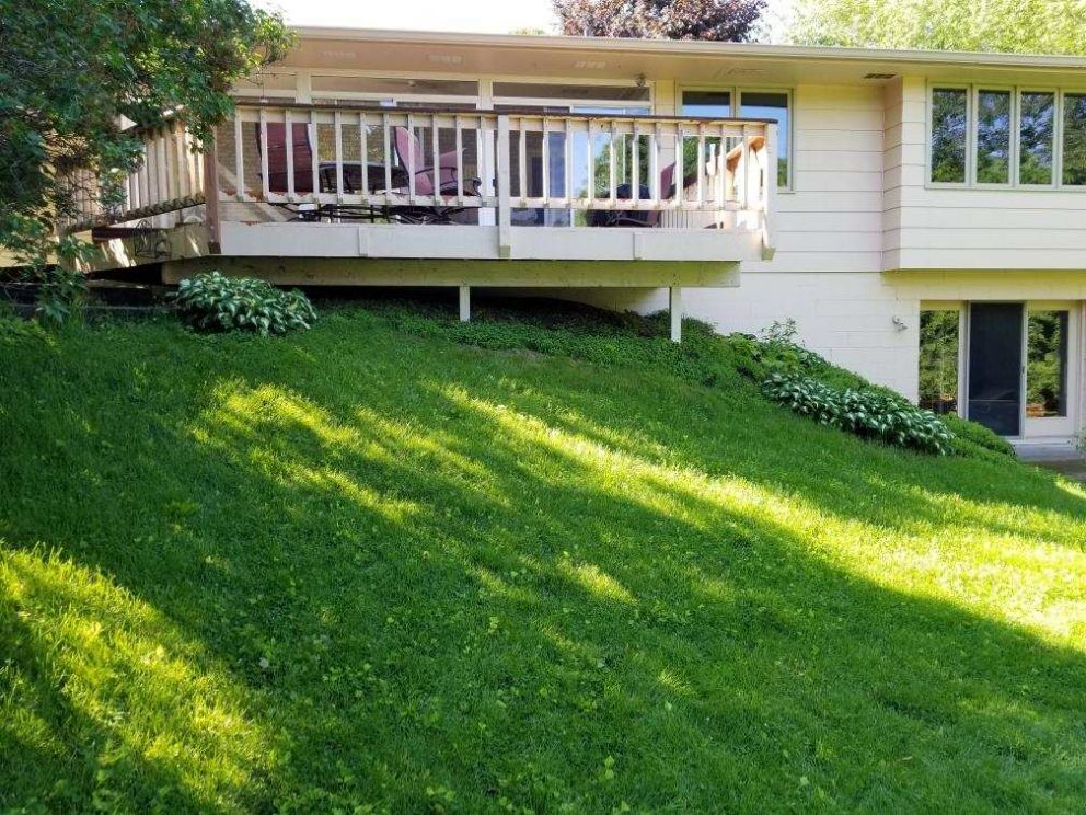 Backyard with a steeply sloped hill on one end