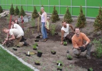 Gardeners looking with a smile for a picture while planting a garden
