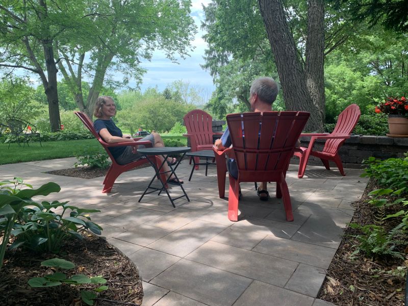 Couple sitting on their patio in red lawn chairs