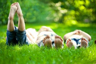 Kids laying in a grass field on their backs