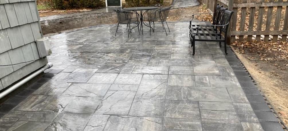 Grey stone patio with a seating area and table