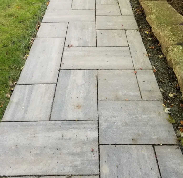 Straight stone walking path that leads through a lawn